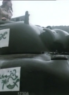 Un tank Sherman de la Seconde Guerre mondiale grossièrement customisé en char arabe dans une clairière boisée et boueuse typiquement moyen-orientale.